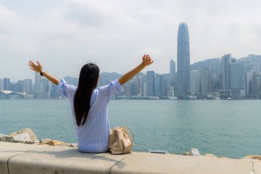 Turist kadın Hong Kong şehrinin manzarasının tadını çıkarıyor.