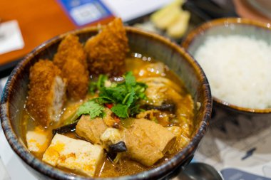 Restoranda kızarmış balık filetosu ve çorba kasesi.