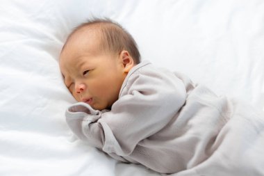 Yeni doğan bebek yatakta yatarken