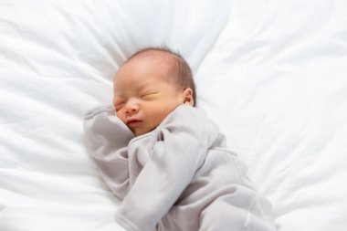 Asyalı küçük çocuk yatakta uyuyor.