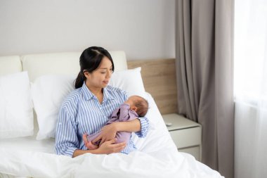 Kadın evde bebeğe bakıyor.