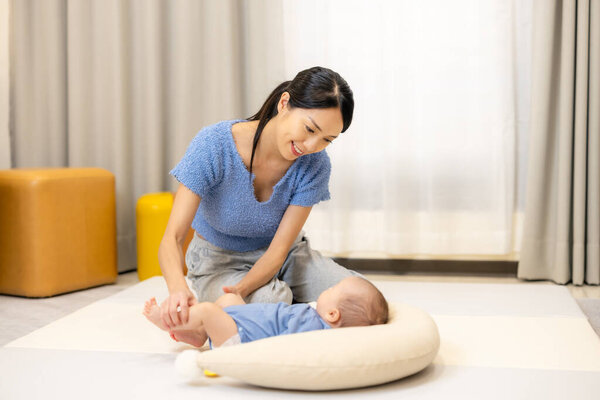 Woman play with her son on play mat at home 