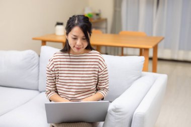 Kadın evde dizüstü bilgisayarda çalışıyor.