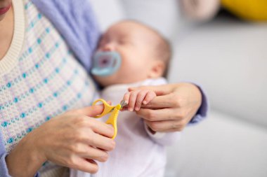 Sevgi dolu anne, bebek tırnaklarını özenle kesiyor.