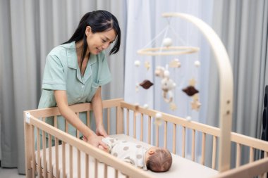 Anne, karnından gaz çıkarmak için oğlunun bacaklarıyla egzersiz yap.