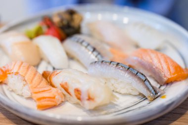 Gurme çeşit çeşit suşi güzel bir tabakta sunuluyor.