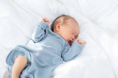 Asyalı bebek yatakta uyuyor.