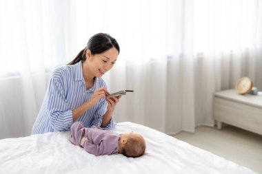 Mutlu anne oğlunun yatağında fotoğraf çekiyor.