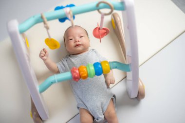 Annem evde erken bebek gelişimi için bebek spor salonuyla oynuyor.