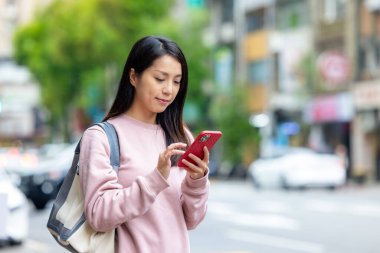 Taipei caddesinde cep telefonu kullanan genç bir kadın.