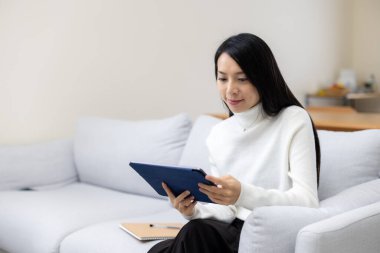 Evde tablet bilgisayarla dinlenen kadın