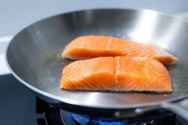 Kızartma tavasında çiğ somon filetosu.