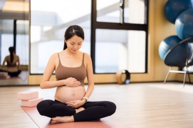 Annemin yoga stüdyosunda göbeğine bakmasını bekliyorum.