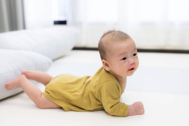  Sevimli bebek içeride rahat bir oyun paspası üzerinde yatıyor.