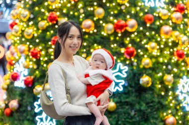 Kutlama etkinliğinde bebeğiyle gülümseyen anne.