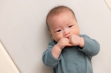 Yeni doğmuş bebeğe yakın, minik elini emiyor.