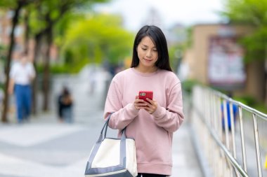 Taipei 'de cep telefonu kullanan bir kadın yolcu.