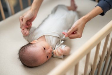 Anne, bebeğin alıştırma yapmasına yardım et.