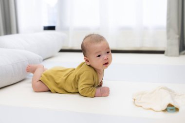 Evdeki yumuşak oyun paspasında emekleyen bebek.