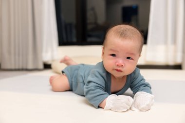 Yeni doğmuş bebek eldivenlerle huzur içinde dinleniyor.