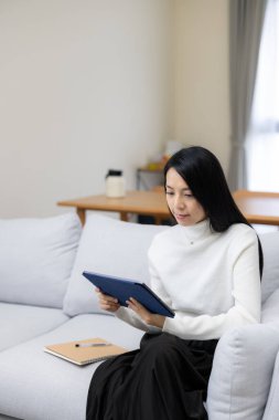 Kadın evde dijital tablet bilgisayarına göz atıyor