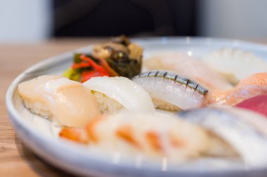 Tabakta çeşitli malzemelerle taze suşi ruloları.