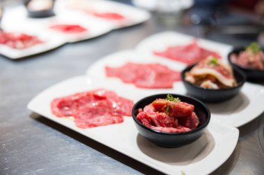 Japon yakiniku barbeküsü ve taze et dilimleri.