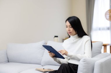 Kapalı alanda tablet bilgisayar kullanan profesyonel bir kadın.