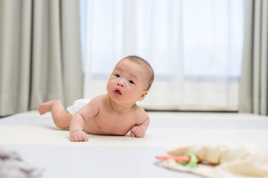 Evdeki oyun hasırında emekleyen bebek.