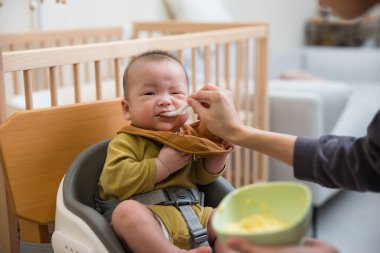 Bebek ilk kez katı yiyecekler yiyor.