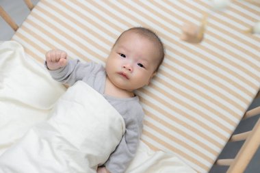 Bebek beşikte yatıyor Asma oyuncakla eğleniyor