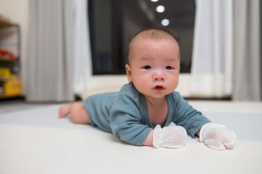 Bebek eldiven takıyor yumuşak paspasın üzerinde sürünüyor