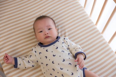 Yeni doğmuş erkek bebek bebek karyolasında yatıyor