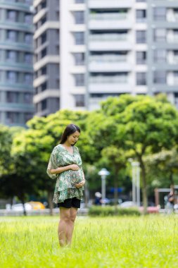 Hamilelik sırasında parkta yürüyen bir kadın.