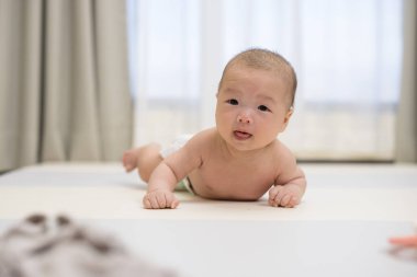 Beyaz paspasın üzerinde tatlı bir bebek emekliyor