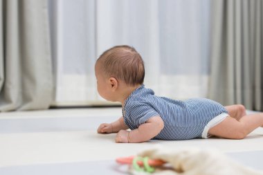 Yeni doğmuş bebek yumuşak oyun paspasında sürünüyor