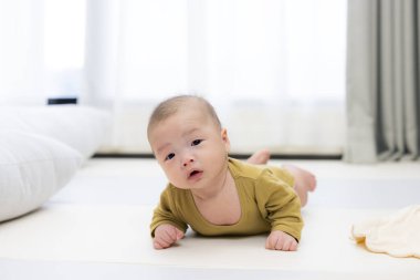 Erken oyun için mindere uzanan bebek