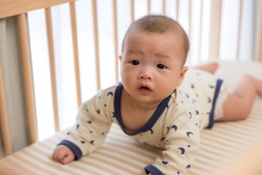 Yeni doğmuş erkek bebek emekliyor ve gülümsüyor