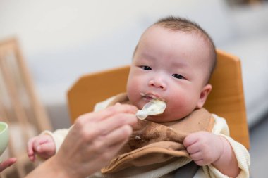 Bebek evde taze yiyecekle mutlu bir şekilde besleniyor.