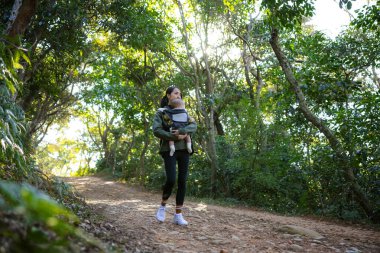 Yürüyüş yapan kadın orman yolunda bebek yürüyüşü yapıyor.