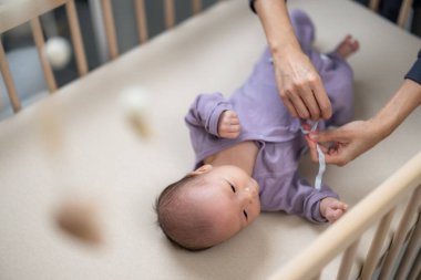 Ebeveynler bebek odasında bebek kıyafetlerini değiştiriyor.