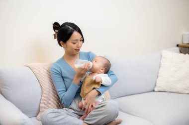 Anne bebeğini süt şişesiyle besliyor.