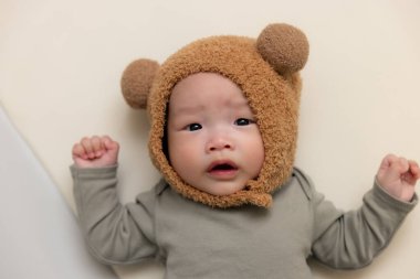 Tüylü hayvan şapkası takan yeni doğmuş bebek.