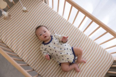 Yeni doğmuş erkek bebek karyolada dinleniyor.