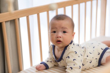 Aktif erkek bebek beşiğinde sürünüyor