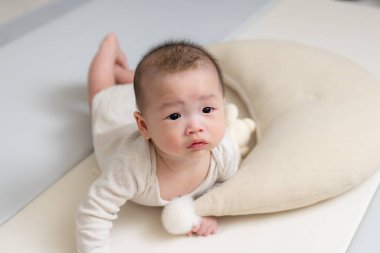 Yeni doğmuş bebek paspasın üzerinde sürünüyor.