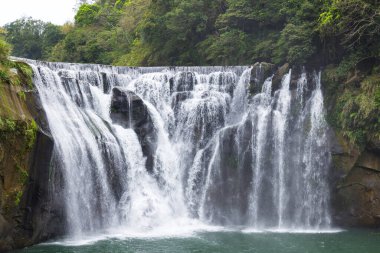 Tayvan 'daki Shifen şelalesi, yemyeşil dağlar. 