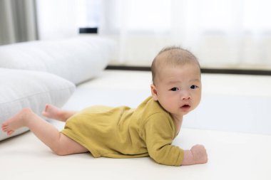 Bebek paspasın üzerinde uzanıp içeride oynuyor.