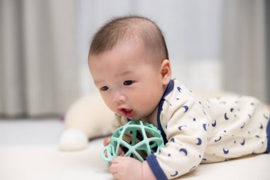 Sevimli bebek halıda oyuncakla oynuyor.