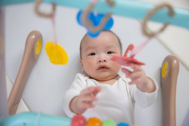 Sevimli bebek asılı oyuncakla oynuyor